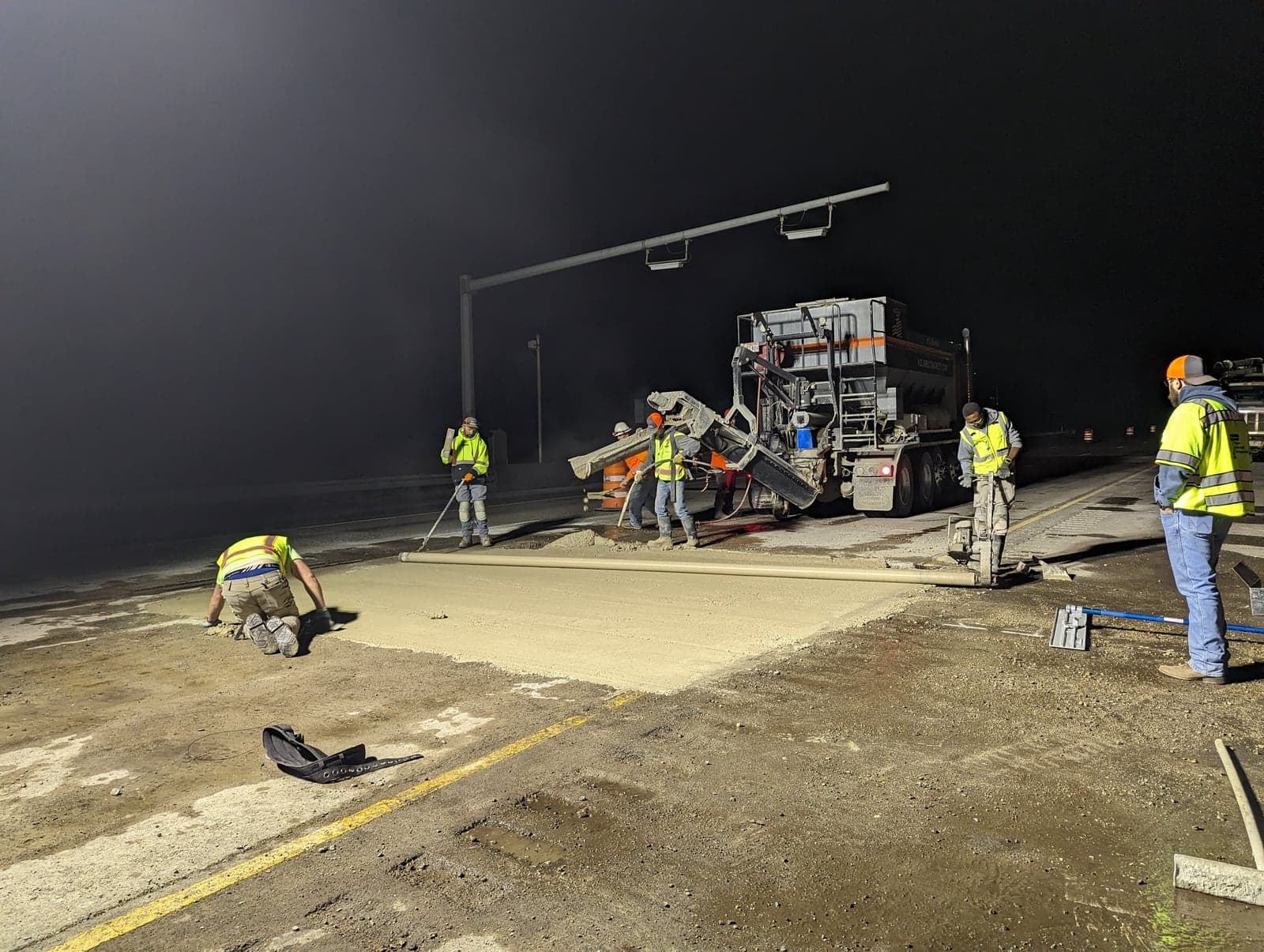 Night highway volumetric pour with crew screeding a road patch