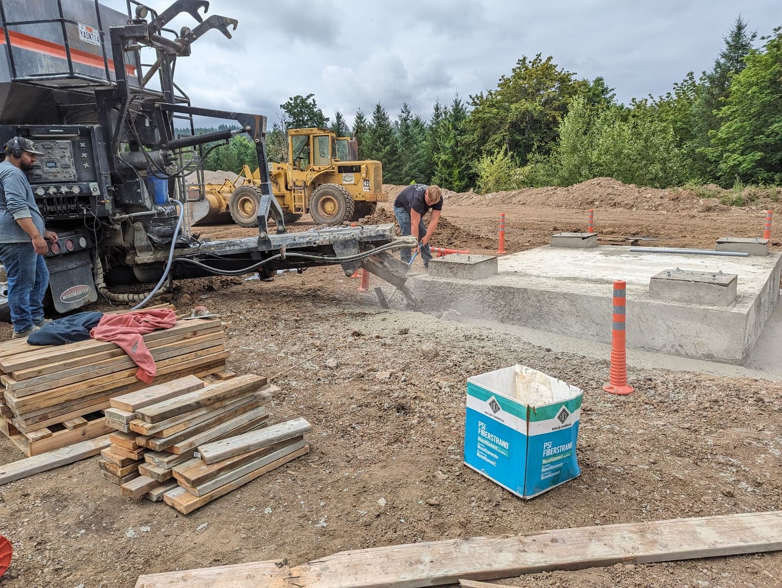 Volumetric mixer chute pouring into a formed pad on a jobsite